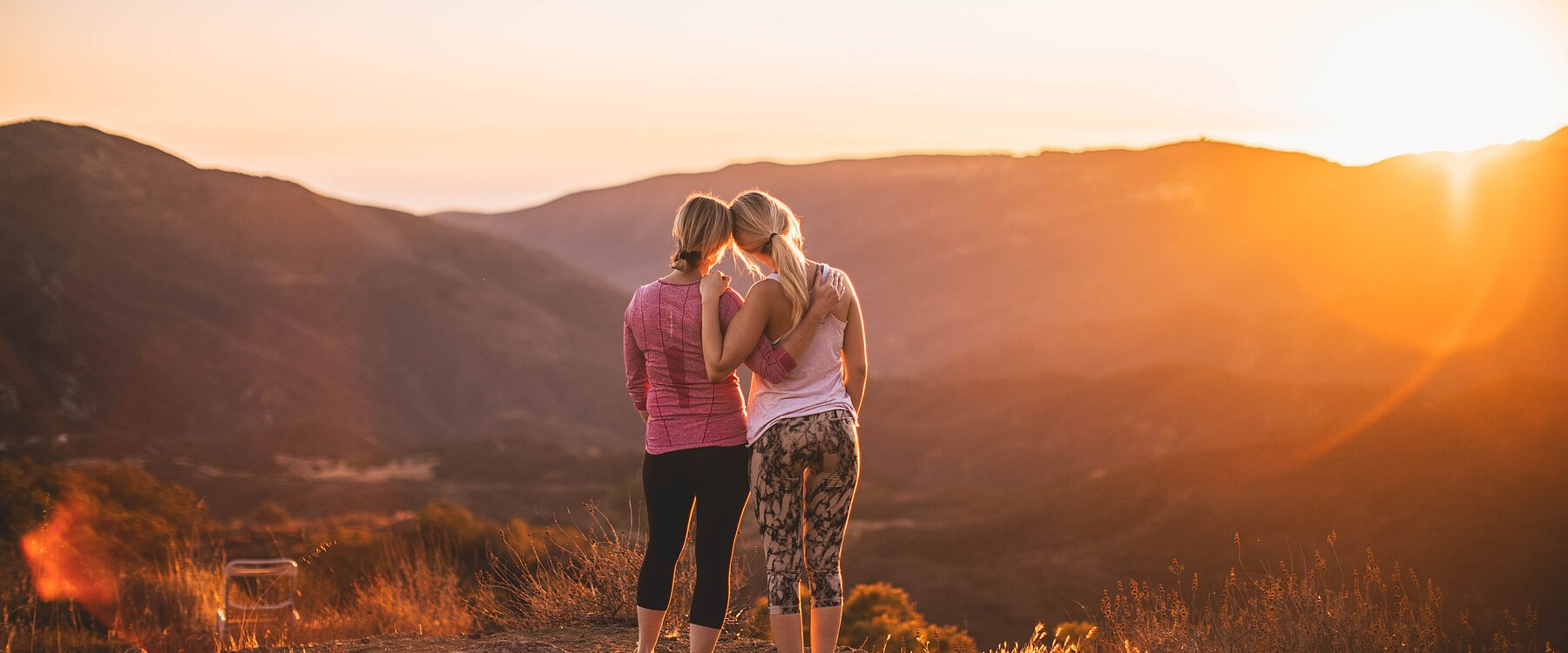 zwei Wanderer die den Sonnenaufgang beobachten beim Sporthotel Goldener Berg