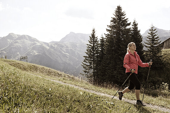 eine Wanderin am Arlberg beim Sporthotel Goldener Berg